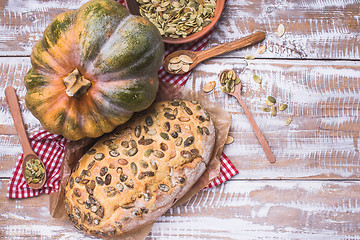 Image showing Rustic style baked bread with seeds and pumpkin on wood