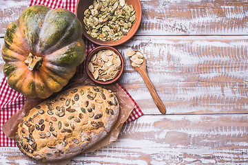 Image showing Newly baked bread with seeds and pumpkin on wooden table