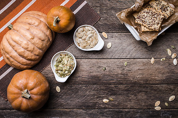 Image showing Rustic pumpkins with cookies and seeds on wood