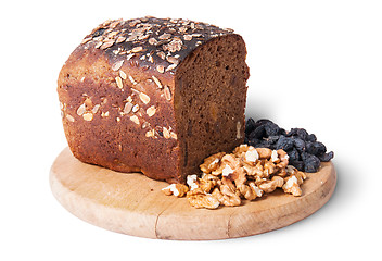 Image showing Bread with seeds on wooden board with raisins and nuts