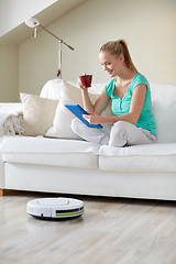 Image showing happy woman with tablet pc drinking tea at home