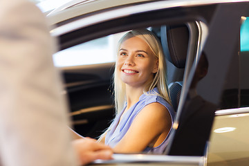 Image showing happy woman with car dealer in auto show or salon