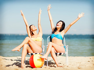 Image showing girls sunbathing on the beach chairs