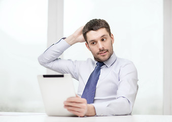 Image showing stressed businessman with tablet pc and documents