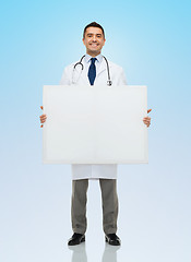Image showing smiling male doctor holding white blank board