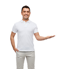 Image showing smiling man showing something on empty palm