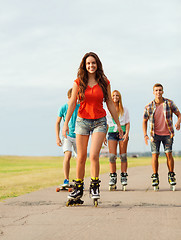 Image showing group of smiling teenagers with roller-skates