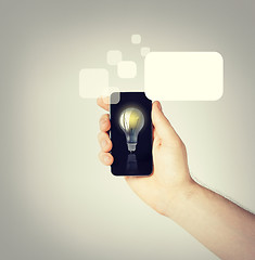 Image showing man hand holding smartphone with light bulb