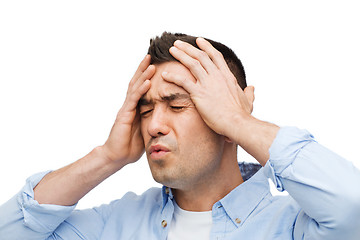 Image showing unhappy man with closed eyes touching his forehead