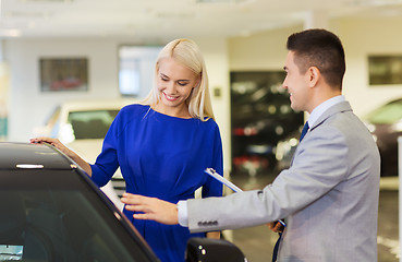 Image showing happy woman with car dealer in auto show or salon