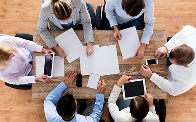 Image showing close up of business team with papers and gadgets