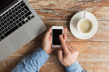 Image showing close up of hands with laptop and smartphone