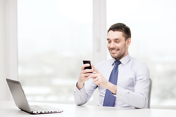 Image showing businessman with laptop and smartphone at office