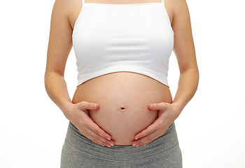 Image showing close up of pregnant woman touching her bare tummy