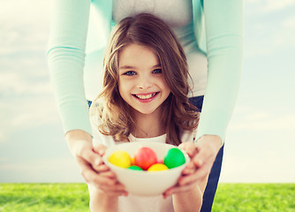 Image showing smiling girl and mother holding colored eggs