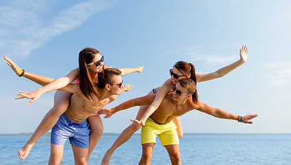 Image showing smiling friends having fun on summer beach