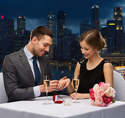 Image showing smiling couple with wedding ring at restaurant