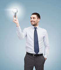 Image showing handsome businessman holding light bulb