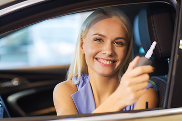 Image showing happy woman getting car key in auto show or salon