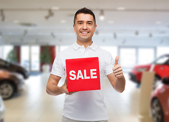 Image showing smiling man with red sale sigh showing thumbs up