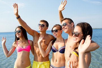 Image showing smiling friends in sunglasses on summer beach