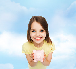 Image showing beautiful little girl with piggy bank