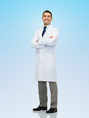 Image showing smiling male doctor in white coat over blue