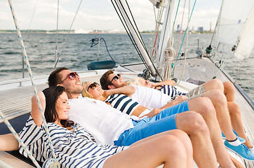 Image showing smiling friends lying on yacht deck