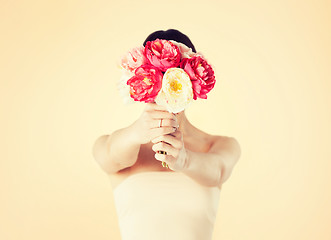 Image showing woman holding bouquet of flowers over her face