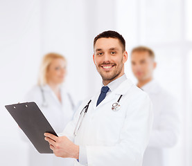 Image showing smiling male doctor with clipboard and stethoscope