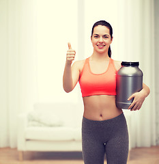 Image showing teenage girl with jar of protein showing thumbs up