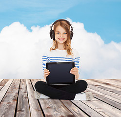 Image showing happy girl with headphones showing tablet pc