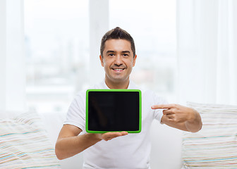 Image showing smiling man showing tablet pc blank screen at home