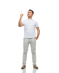 Image showing smiling man pointing finger up