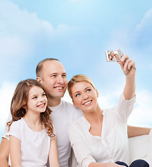 Image showing happy family with camera at home