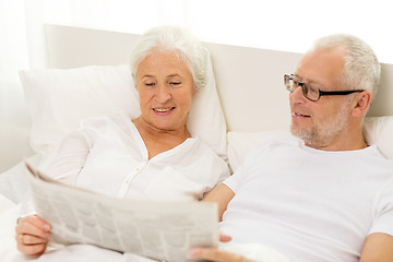 Image showing happy senior couple with newspaper in bed