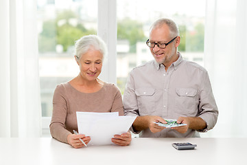 Image showing senior couple with money and calculator at home