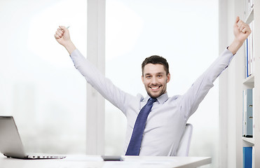 Image showing smiling businessman with laptop and documents