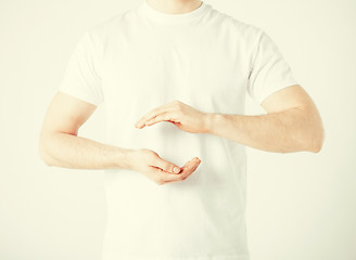 Image showing mans hands showing something