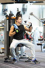 Image showing smiling man exercising on gym machine