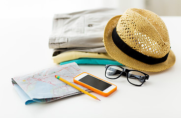 Image showing close up of summer clothes and travel map on table