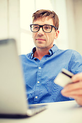 Image showing man with laptop and credit card at home