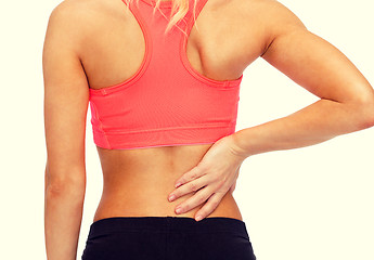 Image showing close up of sporty woman touching her back