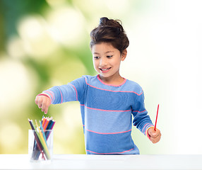 Image showing happy little girl drawing with coloring pencils