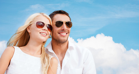Image showing happy couple in shades over blue sky background