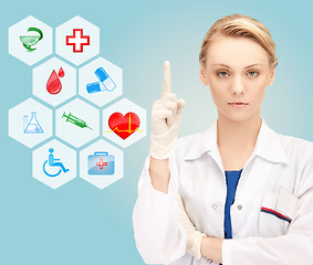 Image showing smiling young female doctor pointing her finger up