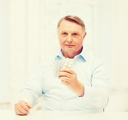 Image showing old man with pack of pills