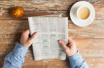 Image showing close up of male hands with newspaper and coffee