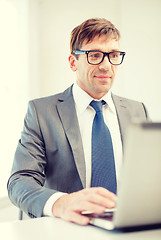 Image showing businessman in eyeglasses with laptop in office