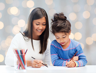 Image showing happy mother and daughter drawing with pencils